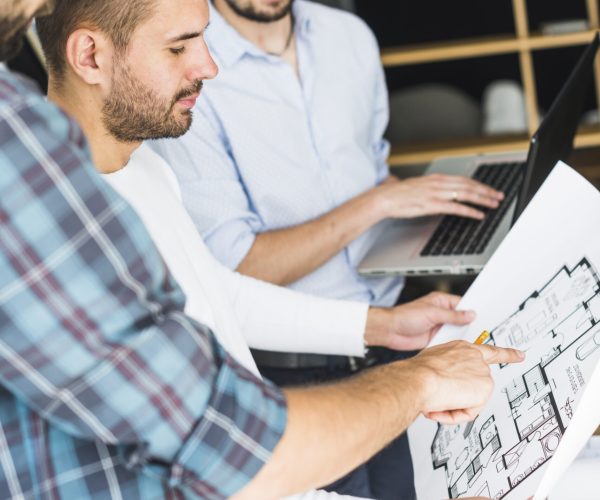 group-male-architect-having-discussion-blueprint